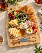 Wooden cheese serving board styled with pastries and cheese