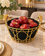 Gold metal fruit basket with black liner holding red apples on dining table