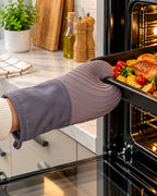 Gray silicone oven mitt with fabric cuff used at oven