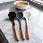 Trendy Shop set of three silicone soup ladles in black, grey, and white with ergonomic wooden handles.