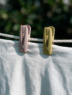 Classic laundry clothes pegs holding a white garment on a clothesline