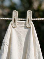 Floral laundry clothes pegs holding a white garment on a clothesline