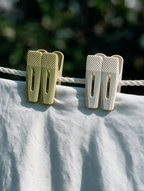 Grip-tip laundry clothes pegs holding a white garment on a clothesline