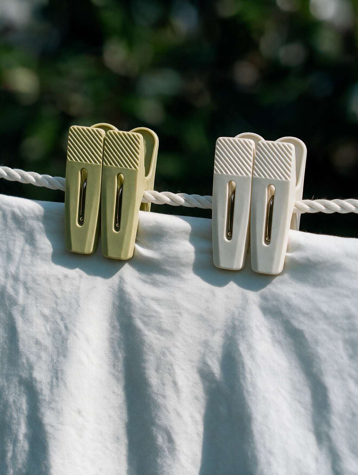 Grip-tip laundry clothes pegs holding a white garment on a clothesline