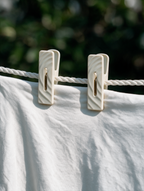 Wave-texture laundry clothes pegs holding a white garment on a clothesline
