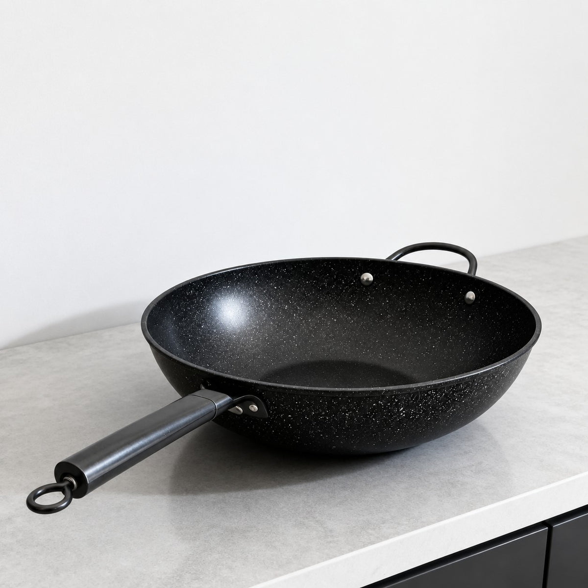 Vallena professional-grade black granite coated fryer with a long handle and dual side loops on a kitchen counter.
