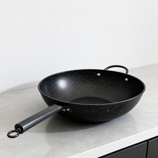 Vallena professional-grade black granite coated fryer with a long handle and dual side loops on a kitchen counter.