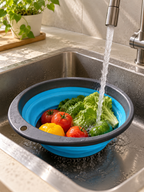 Collapsible silicone colander washing fresh vegetables in a kitchen sink