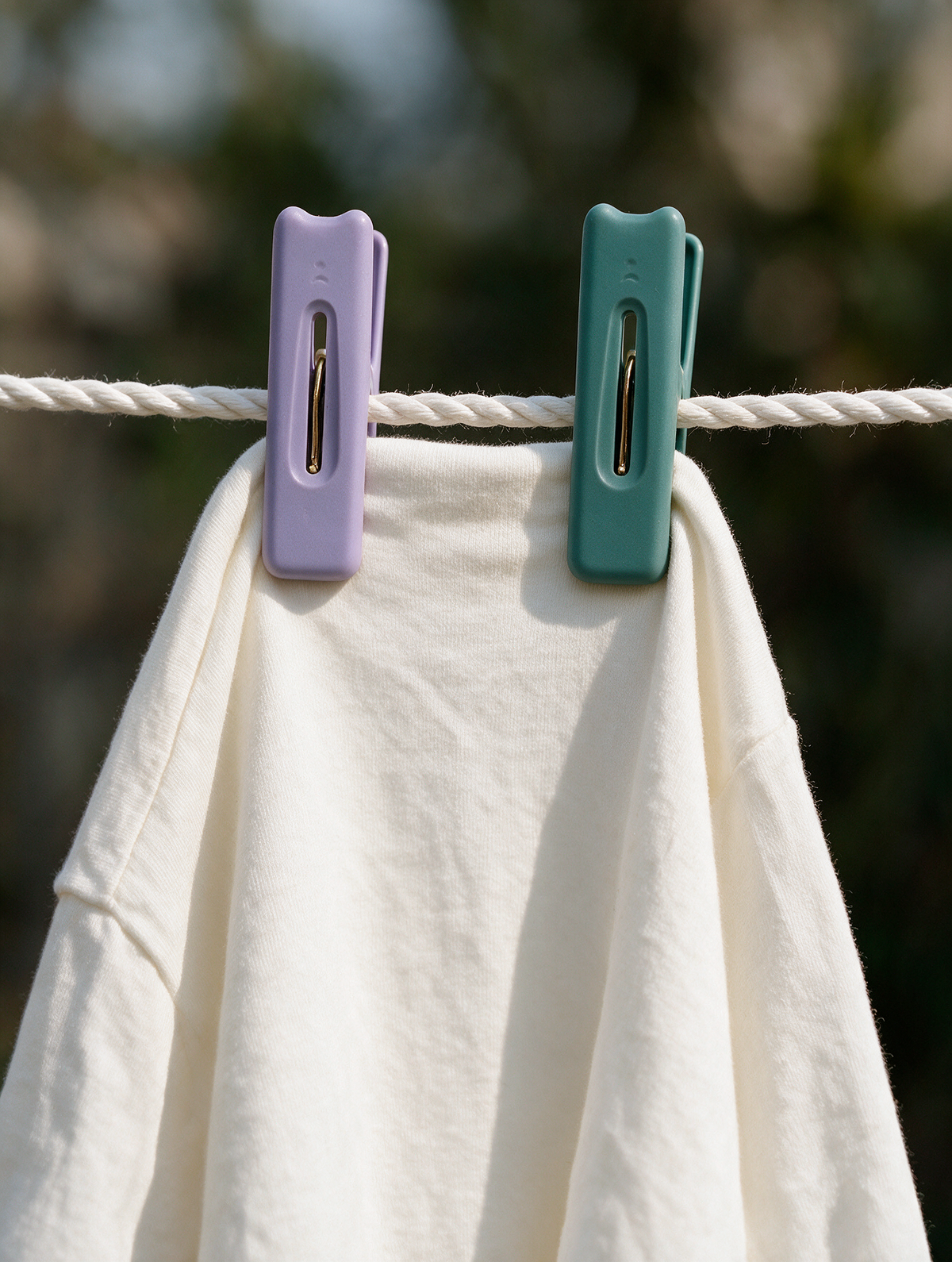Laundry clothes pegs holding a white garment on a clothesline