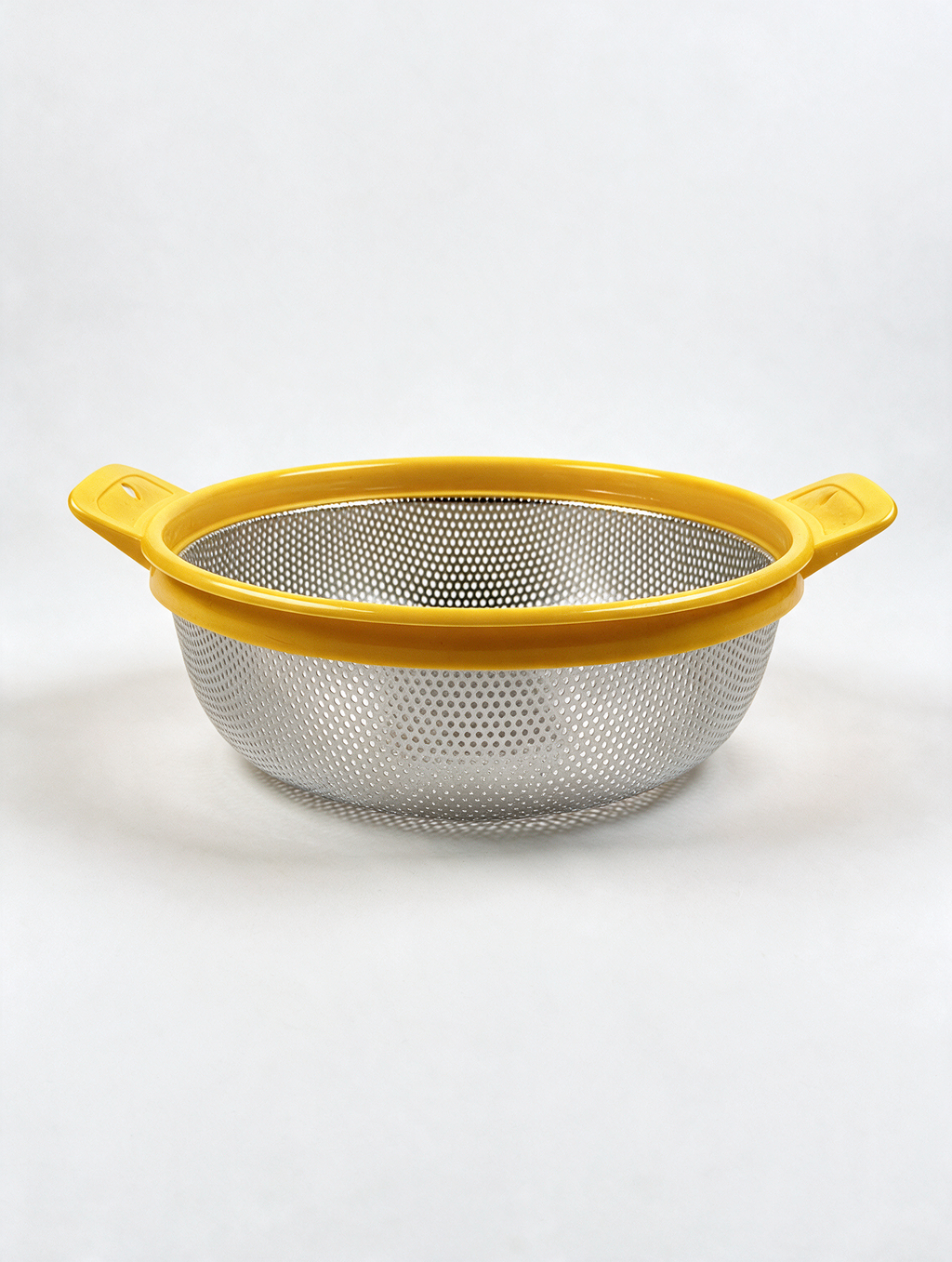 Stainless steel colander with yellow handles and rim on white background